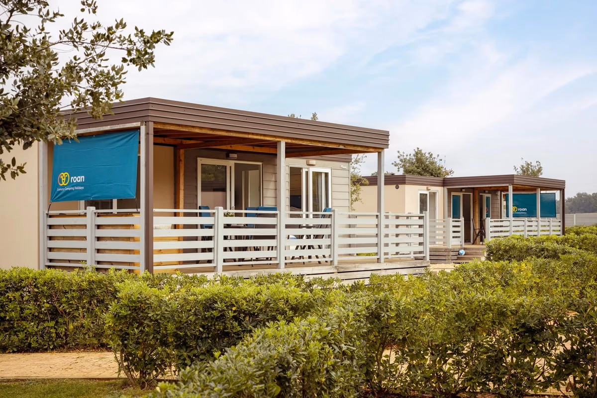 Rij stacaravans met witte terrasafscheidingen achter een haag in de Premium Zone van Camping Park Umag