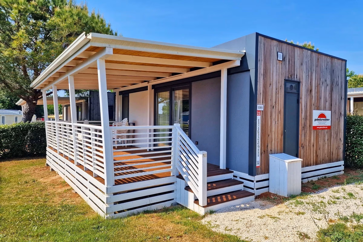 Moderne stacaravan met houten zijgevel en een wit overdekt terras op Camping Park Umag