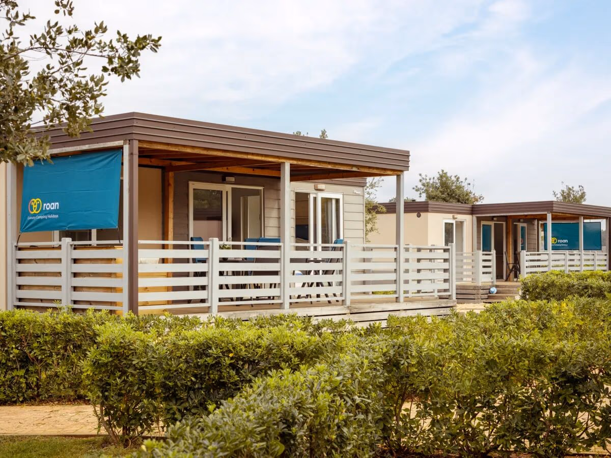 Rij stacaravans met witte terrasafscheidingen en een bruine overkapping in de Premium Zone van Camping Park Umag