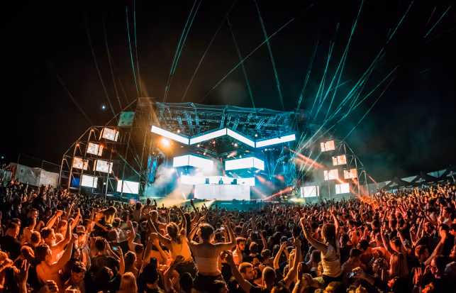 Dansend publiek voor een verlicht podium met lasers tijdens het Sea Star Festival in Umag