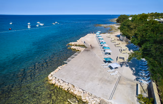 Betegeld strand met ligbedden aan zee op Camping Park Umag